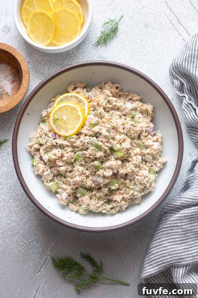Creamy Canned Salmon Salad Recipe with Lemon and Dill 3 Salad with canned salmon in a bowl with lemon slices and dill.