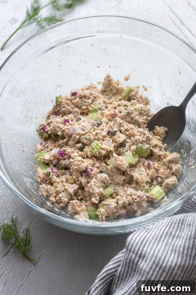 Creamy Canned Salmon Salad Recipe with Lemon and Dill 8 Salmon salad in a mixing bowl with a spoon.