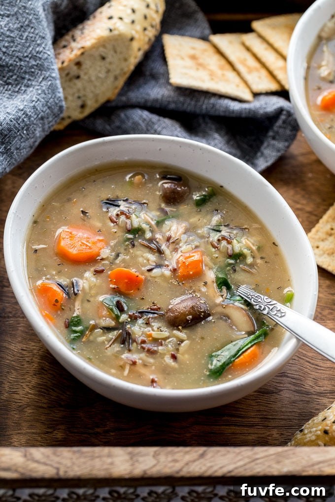 Up-close view of instant pot wild rice soup with chicken in a white bowl.