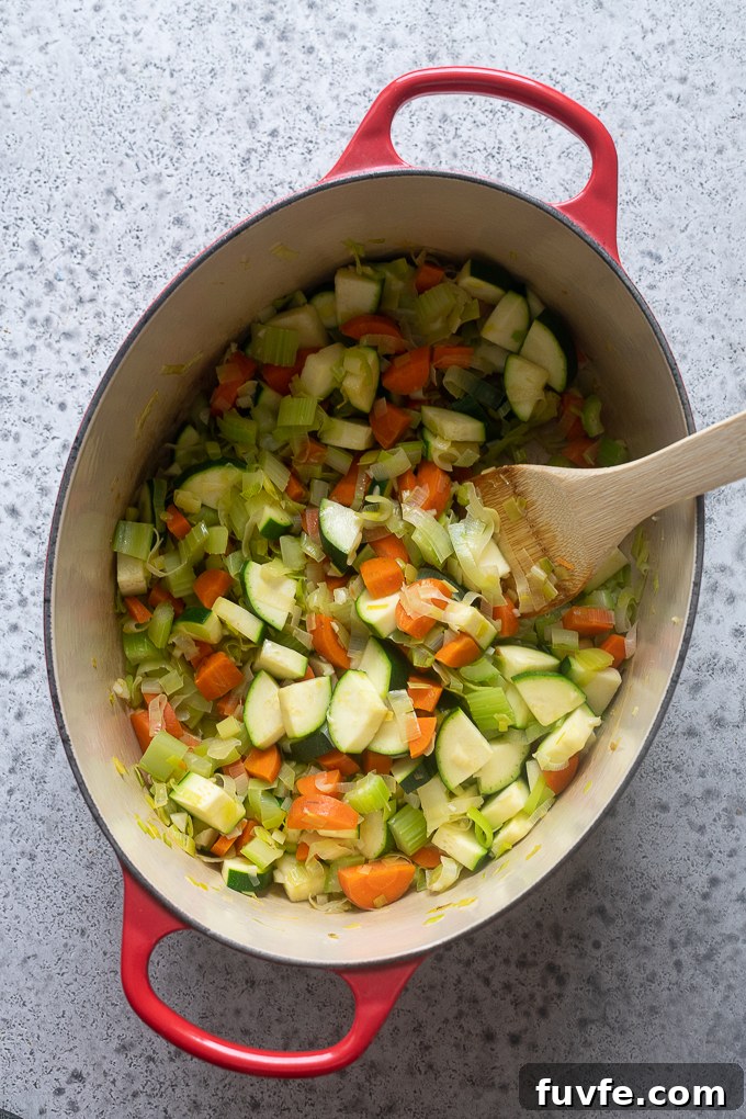 Cooked aromatics and zucchini for summer vegetable soup with pesto.