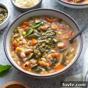 Summer vegetable soup with pesto in a bowl.