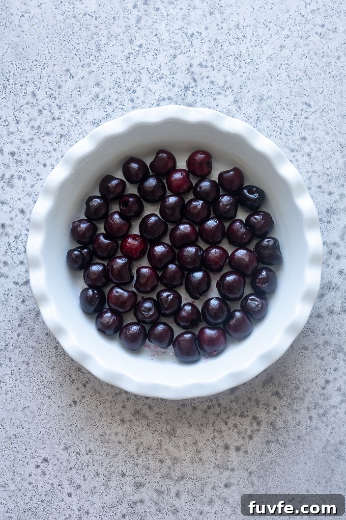Place pitted cherries in a greased 9" baking dish.