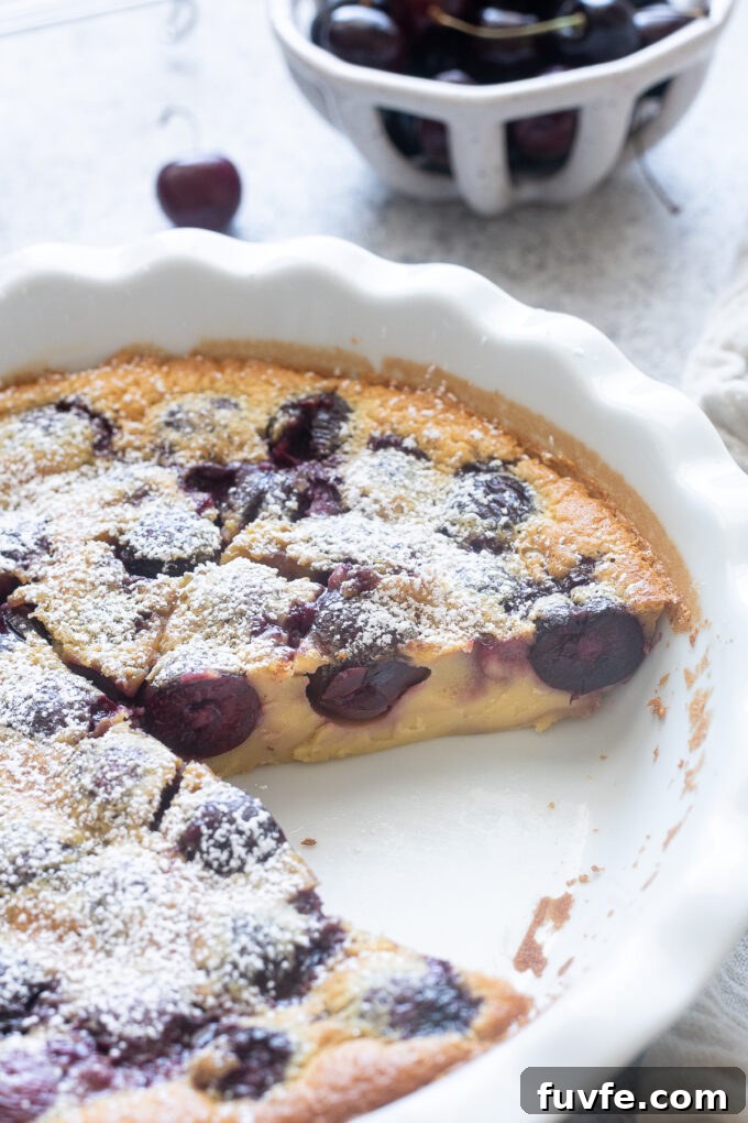 Classic French cherry clafoutis sliced in the pan.