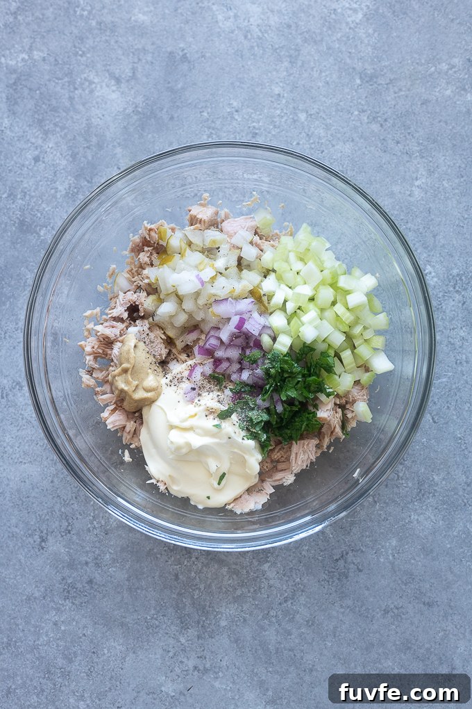 Tuna salad with pickle ingredients in a mixing bowl.
