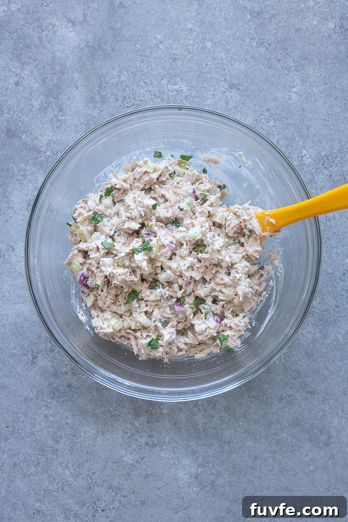 Dill pickle tuna salad combined in a mixing bowl.