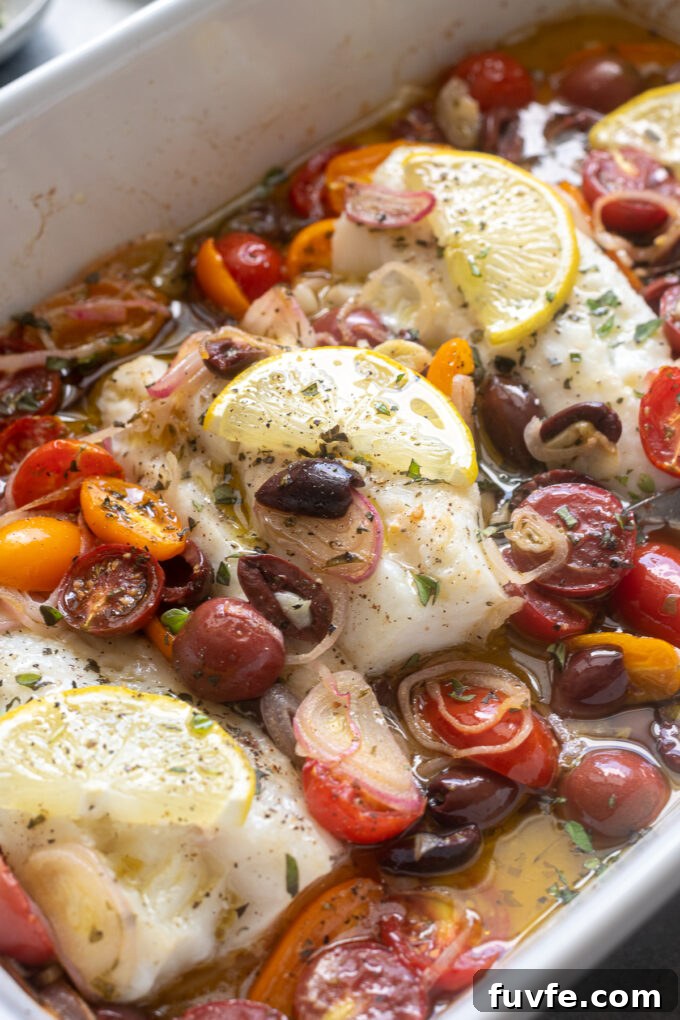 Mediterranean Baked Cod with Cherry Tomatoes, Olives and Lemon 3 Baked cod with cherry tomatoes, olives, and lemon in a white baking dish.