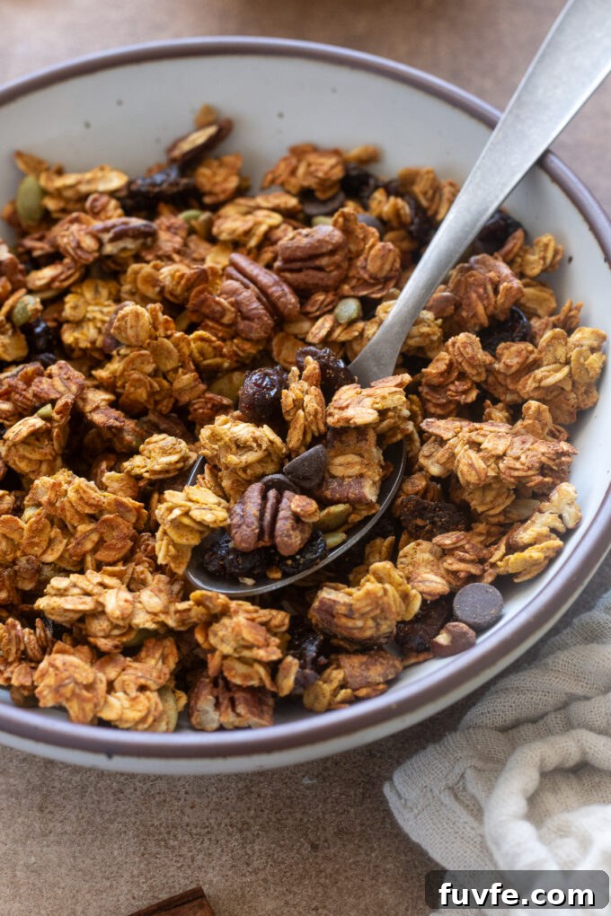 Spoonful of pumpkin spice protein granola in a bowl.