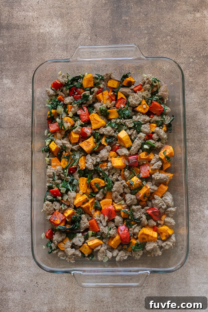Overnight Sausage and Egg Breakfast Casserole 9 Filling for sausage and egg breakfast casserole in baking dish.