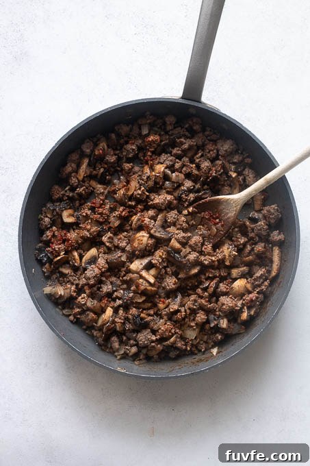 Saute aromatics, ground beef and tomato paste for spaghetti squash casserole.