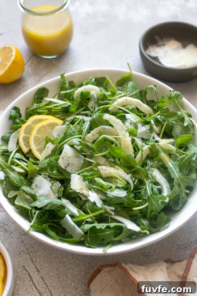 Shaved fennel salad with arugula and parmesan in a bowl.