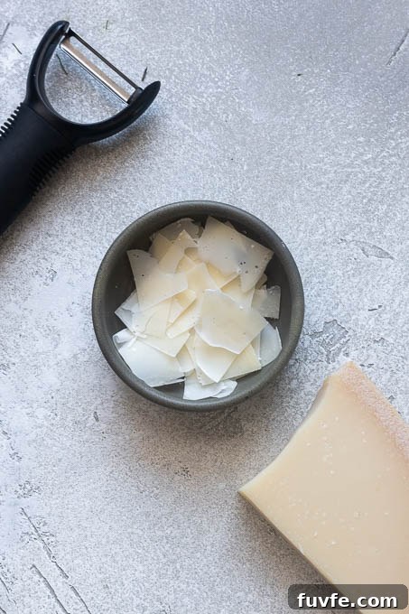 Shaved parmesan in a bowl for arugula fennel salad.