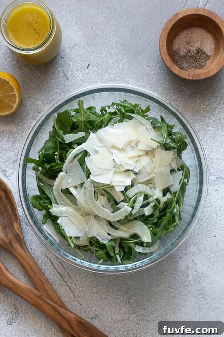 Fennel and arugula salad with parmesan ingredients in a bowl.