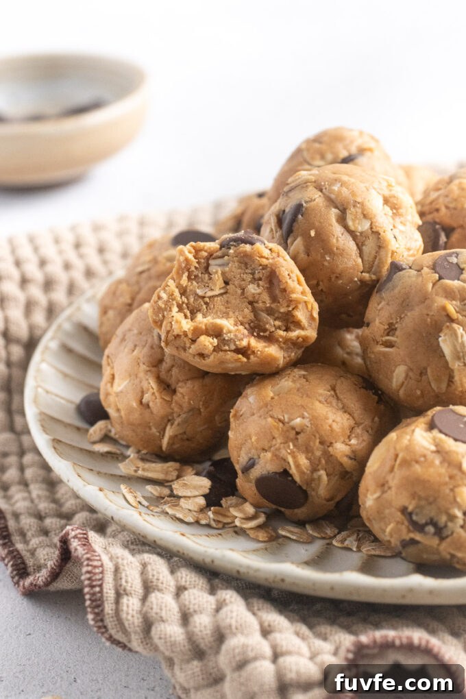 No-Bake Peanut Butter Protein Balls Recipe 9 No-bake peanut butter protein balls on a plate with bite out of one ball.
