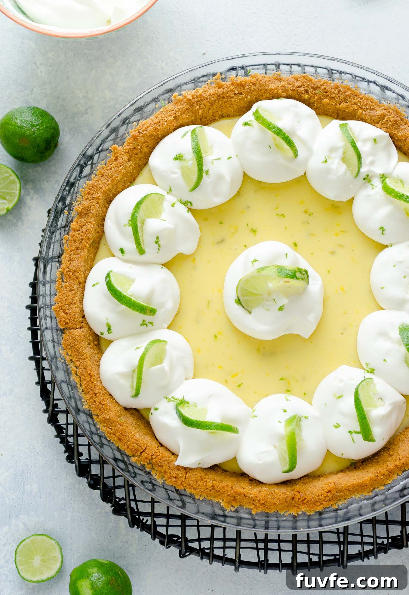 Key lime pie with whipped cream and lime slices