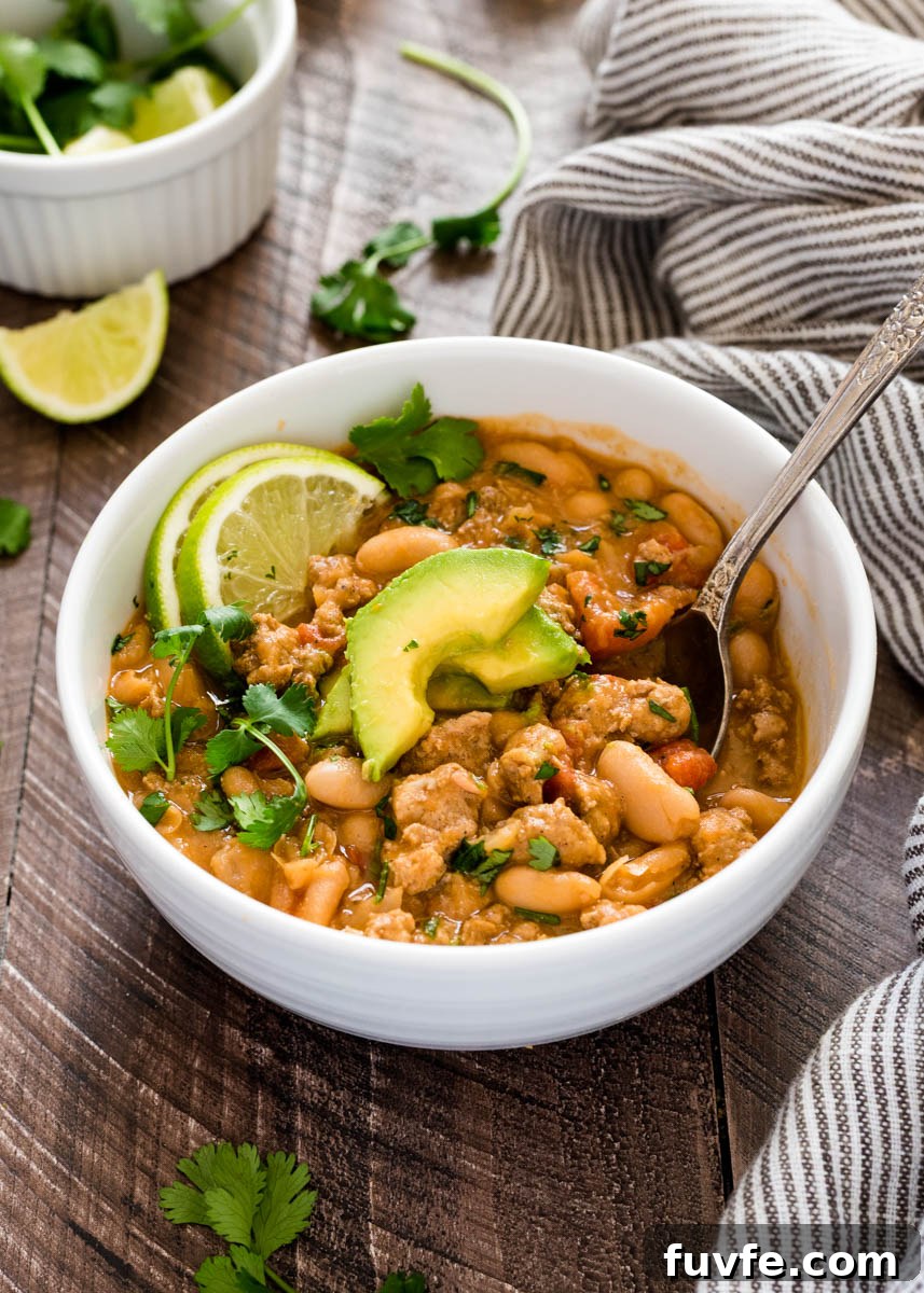 Spoon in bowl of white bean turkey chili.