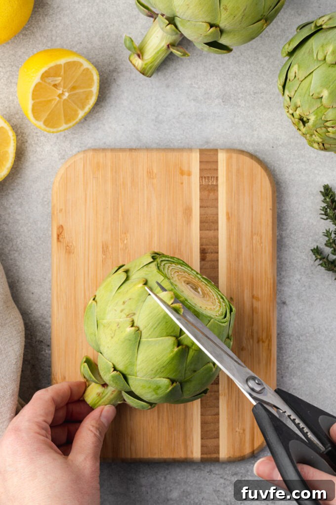 How to Prepare Artichokes for Cooking 6 Kitchen shears trimming sharp tips from artichoke leaves.