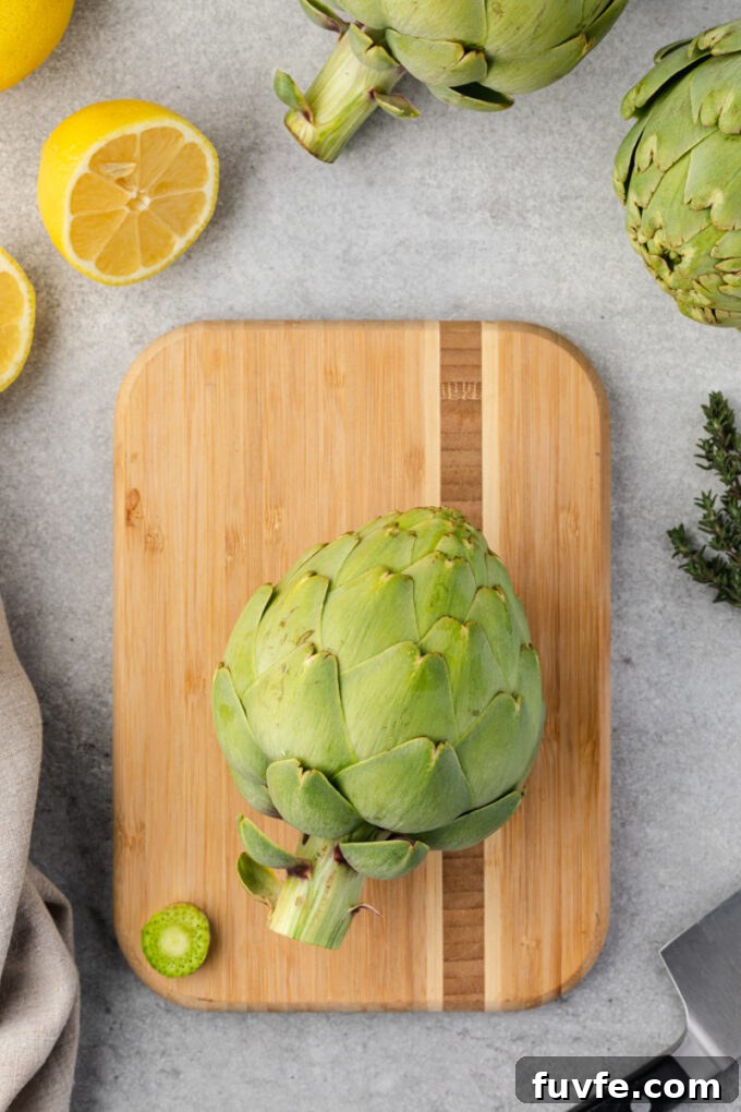 How to Cook Tender Instant Pot Artichokes 4 Artichoke with stem trimmed on cutting board.