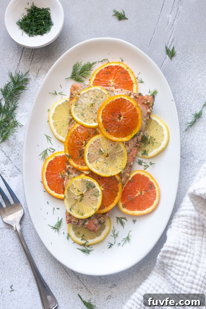 Slow roasted citrus salmon on a platter with lemon and orange slices.