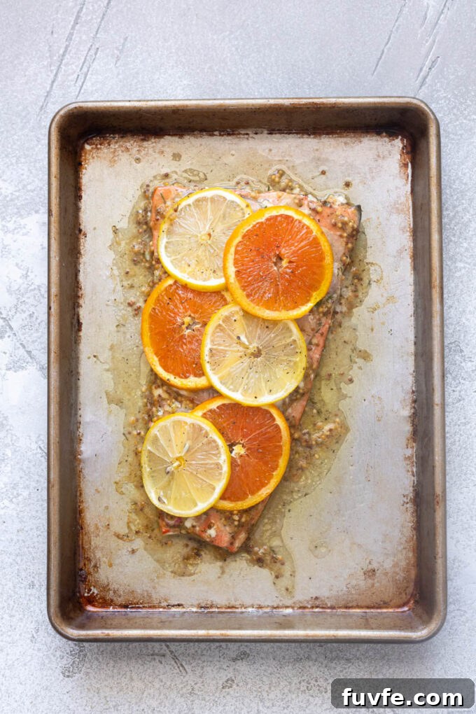 Juicy slow roasted citrus salmon on a baking sheet.