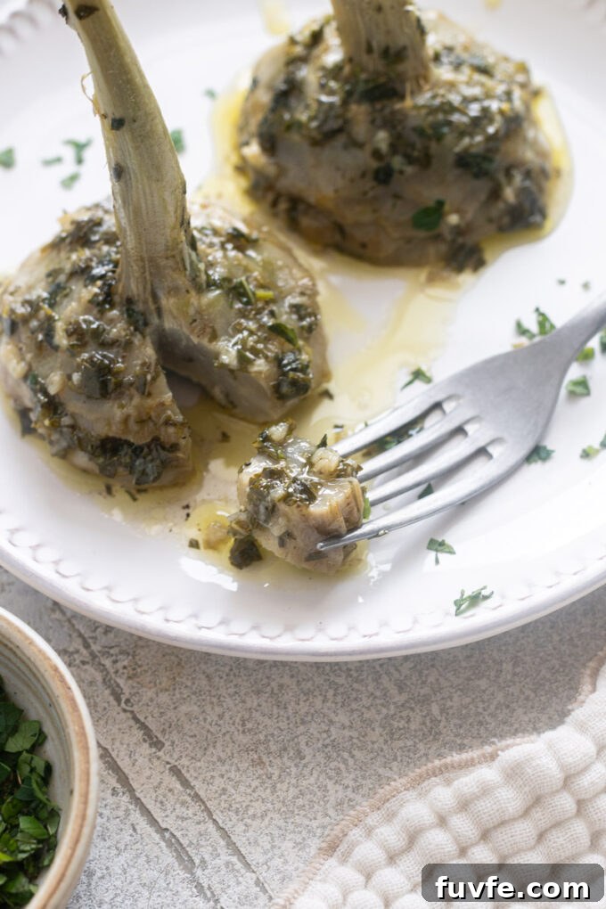 Carciofi alla Romana: Roman-Style Artichoke Recipe 14 Roman artichokes, or Carciofi alla Romana, on a serving plate with slice removed.