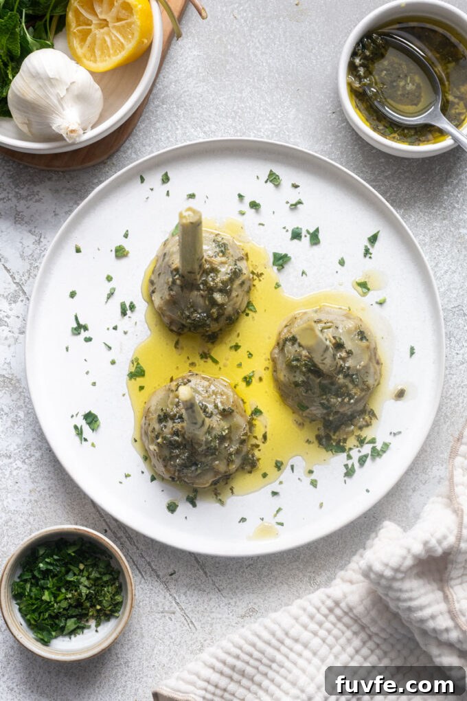 Carciofi alla Romana: Roman-Style Artichoke Recipe 3 Overhead of Roman-style artichokes on a plate with olive oil herb sauce.