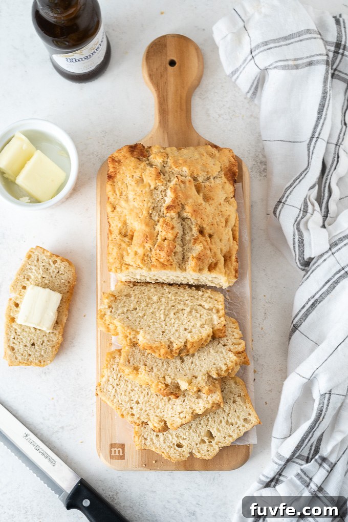 Brown-Butter Maple Beer Bread Recipe 8 Loaf of sliced beer bread with butter in a ramekin