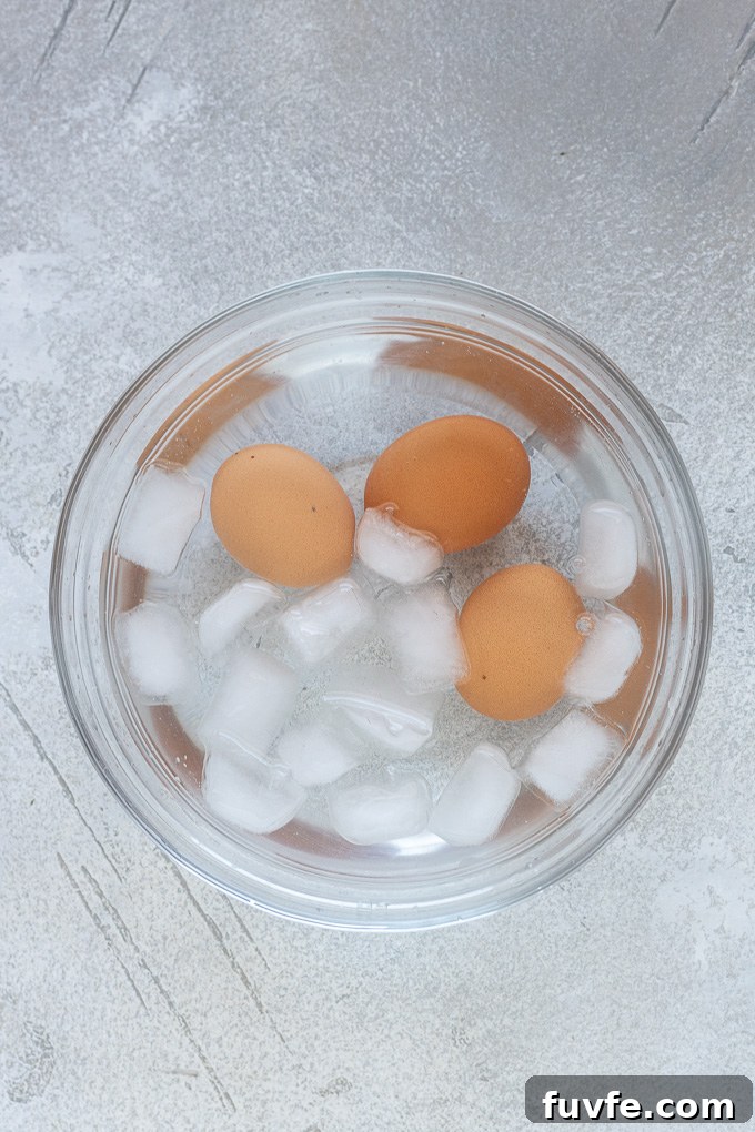 Air fryer hard boiled eggs in bowl of ice water.
