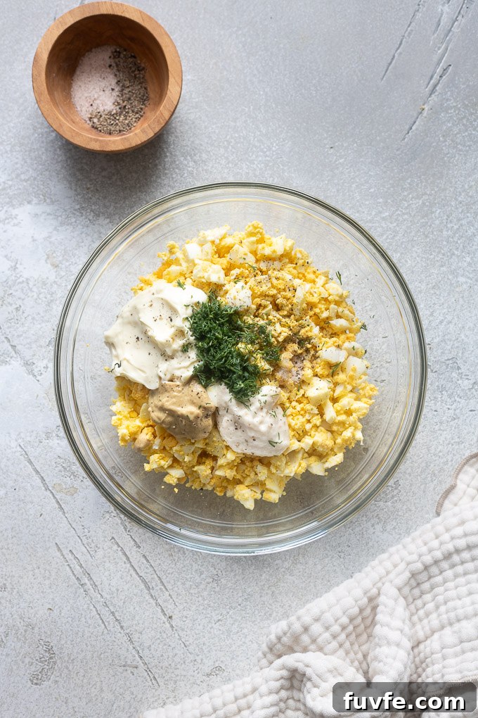 Egg salad with dill recipe ingredients in a mixing bowl.