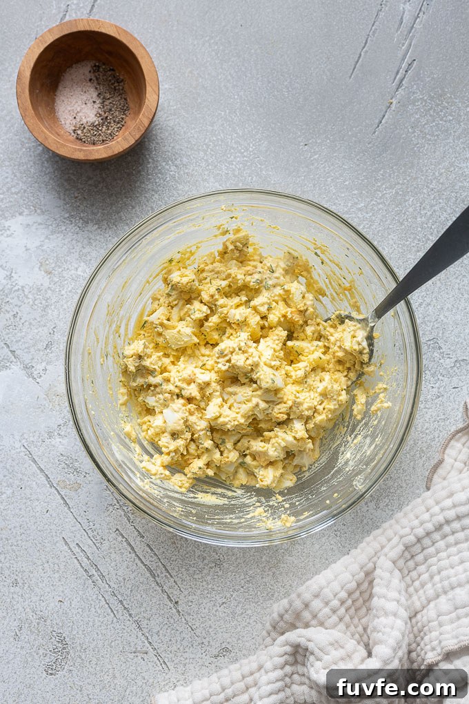 Egg salad with dill recipe combined in a mixing bowl.