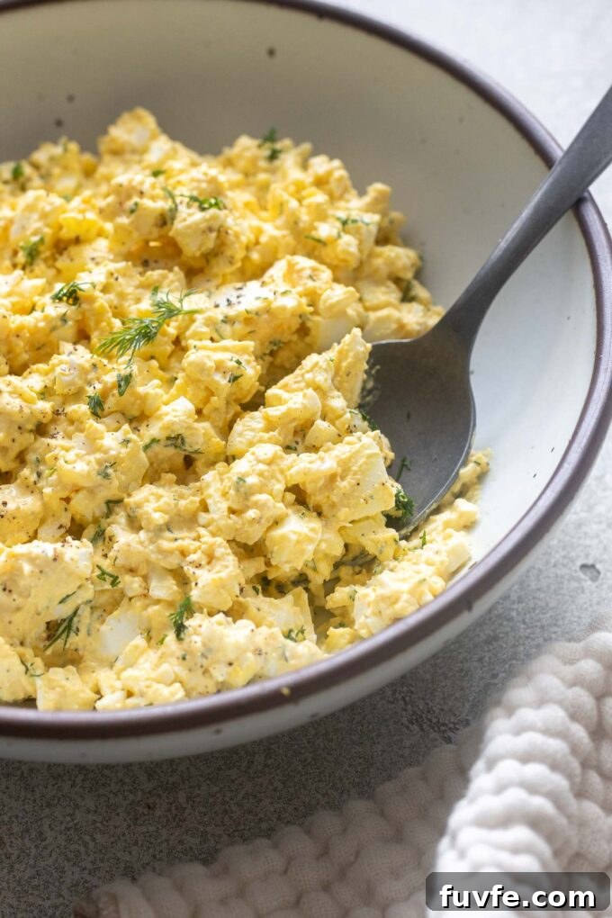 Spoonful of egg salad showing creamy texture and chopped eggs.