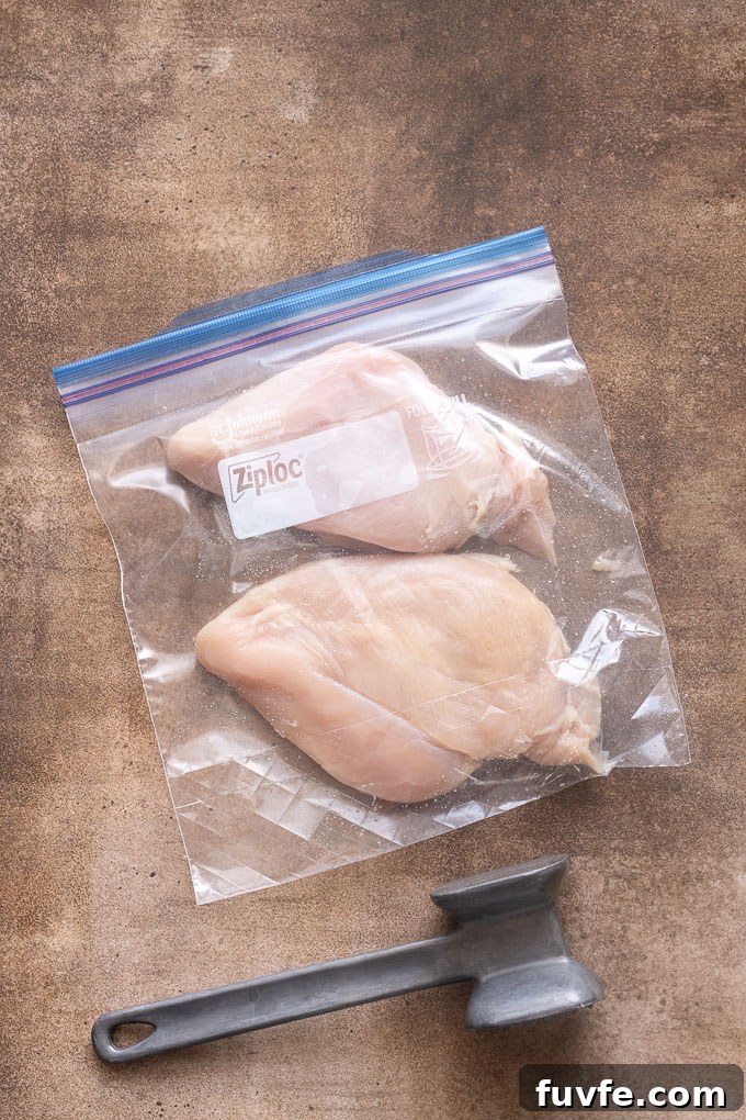 Chicken breasts pounded to even thickness in a zip top bag.
