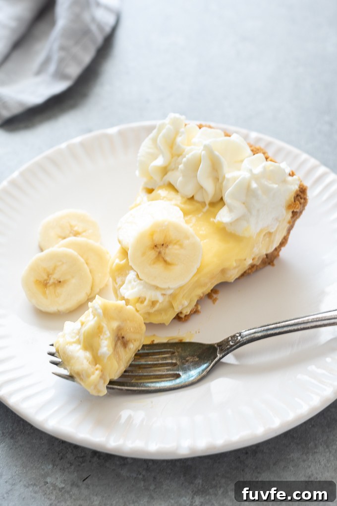 Banana Cream Pie Recipe with Graham Cracker Crust 9 Slice of banana cream pie on a white plate