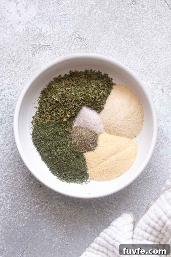 How to Make Homemade Ranch Seasoning Mix 5 Ranch seasoning ingredients sectioned out in a white bowl.