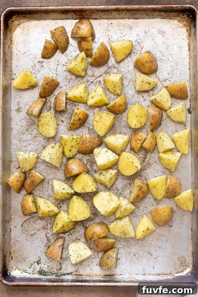 Crispy Ranch Roasted Potatoes Recipe 7 Baby gold potatoes coated with oil, ranch seasoning, salt and pepper on baking sheet.