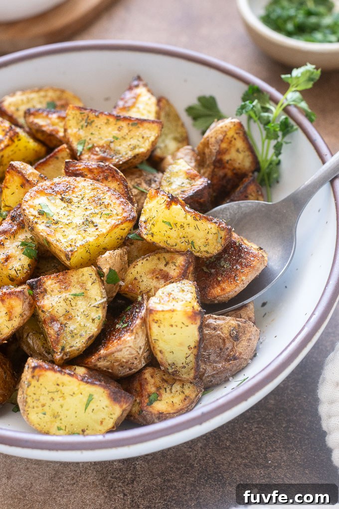 Crispy Ranch Roasted Potatoes Recipe 9 Roasted ranch potatoes in a bowl in with serving spoon.