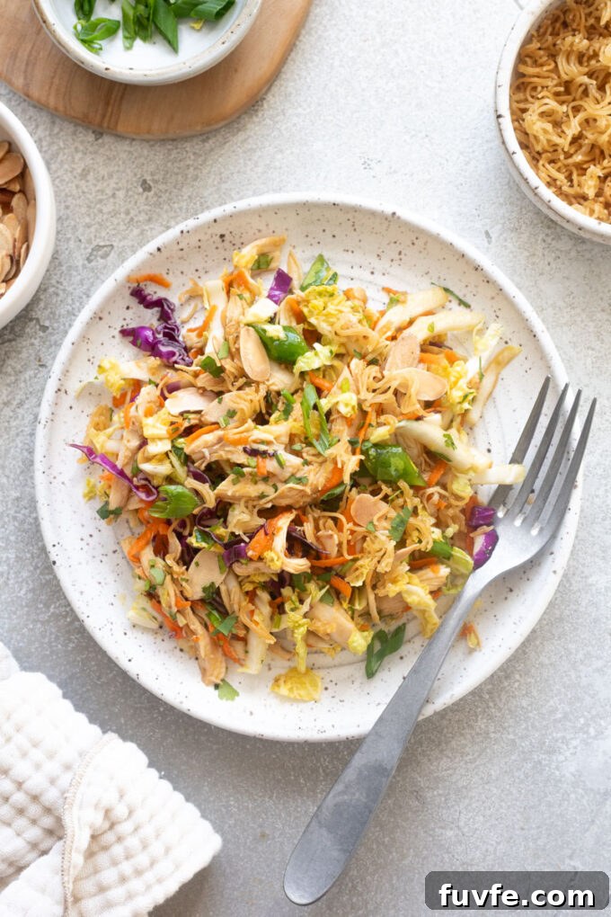 Asian chicken salad on a plate with a fork.