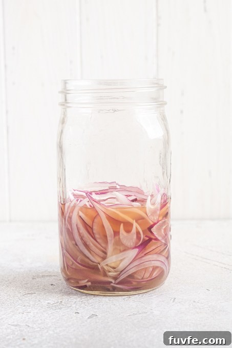 Jar of sliced red onions in brine.