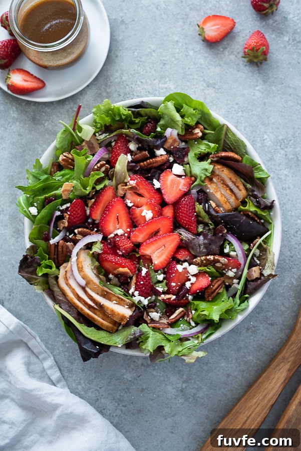 15+ High-Protein Salad Recipes for Filling Lunches and Dinners 7 overhead shot of strawberry fields salad in white serving bowl with wooden servers