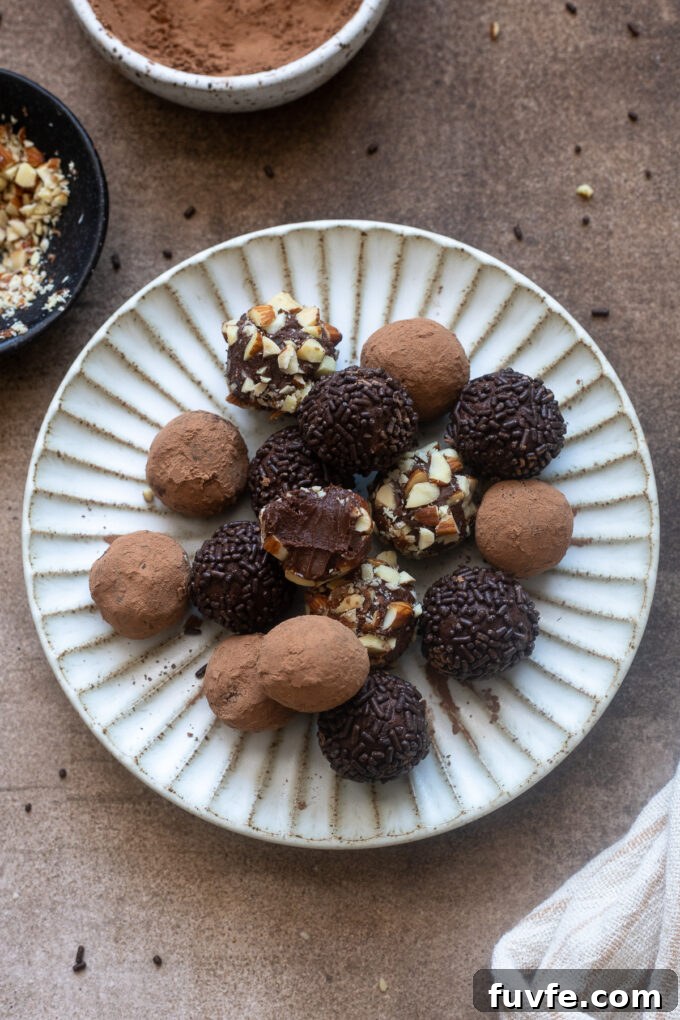 Chocolate caramel truffles on a plate with one bitten in half.