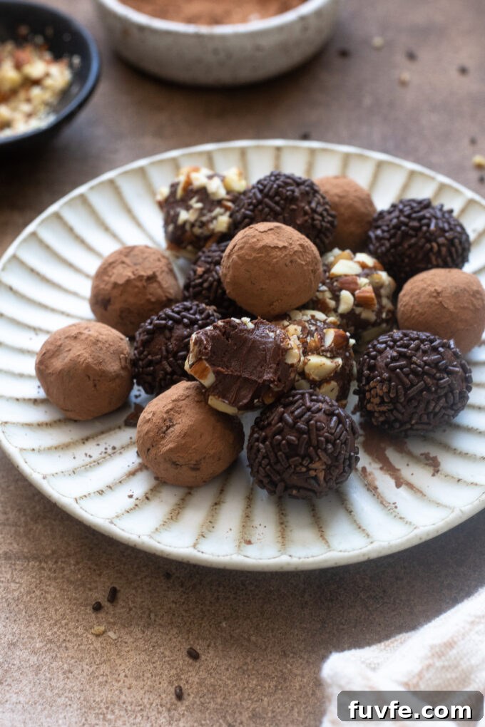Salted caramel truffles on a plate with top truffle bitten in half.