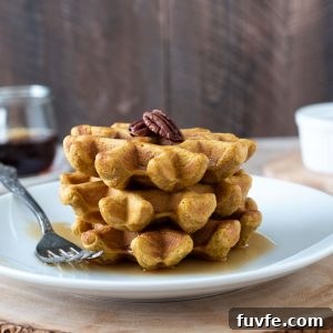 Stack of gluten-free sweet potato waffles on a white plate.
