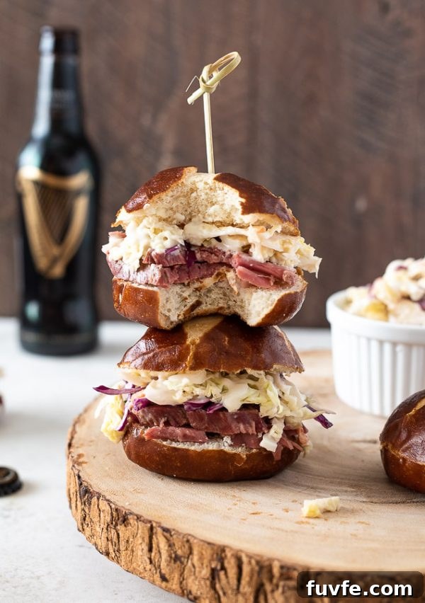 Crispy Corned Beef Sliders with Pickle Slaw 4 guinness corned beef sliders stacked on top of each other with a bottle of Guinness in background