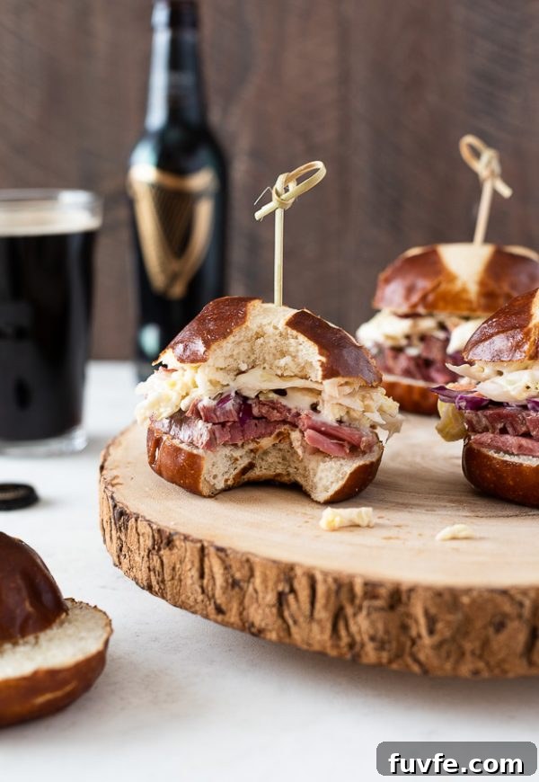 Reuben Style Corned Beef Sliders with Swiss and Sauerkraut 5 close up of corned beef slider with bite taken out of it