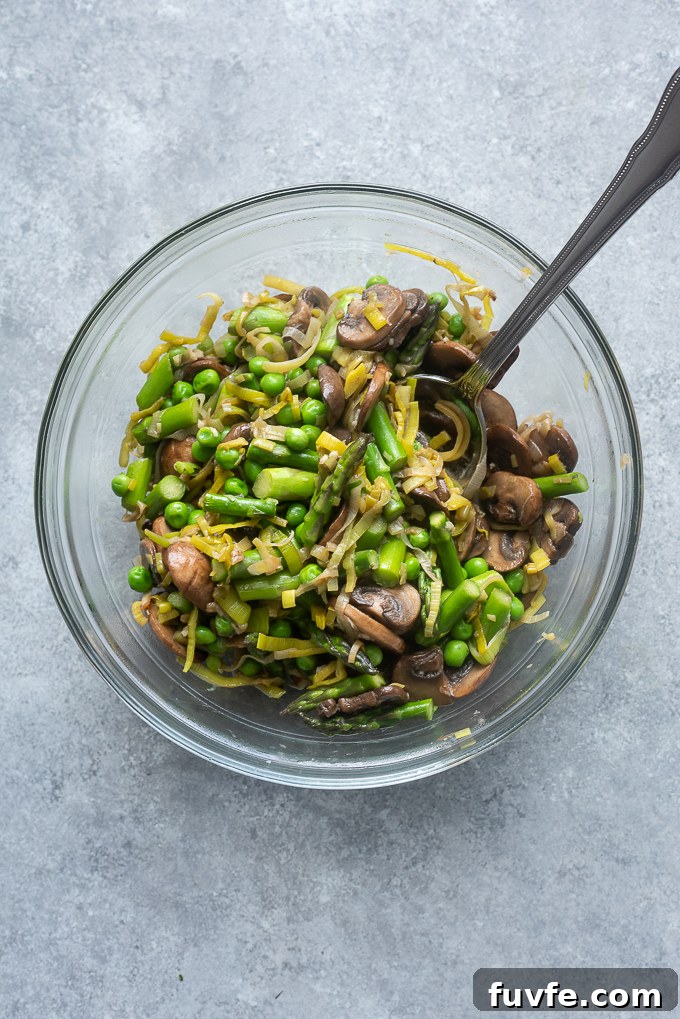 One-Pot Spring Primavera Pasta 4 Cooked spring vegetables in a bowl.