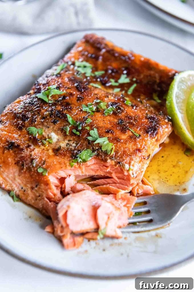Pan-Seared Cajun Blackened Salmon Recipe 2 Blackened salmon on a plate with a fork flaking a corner