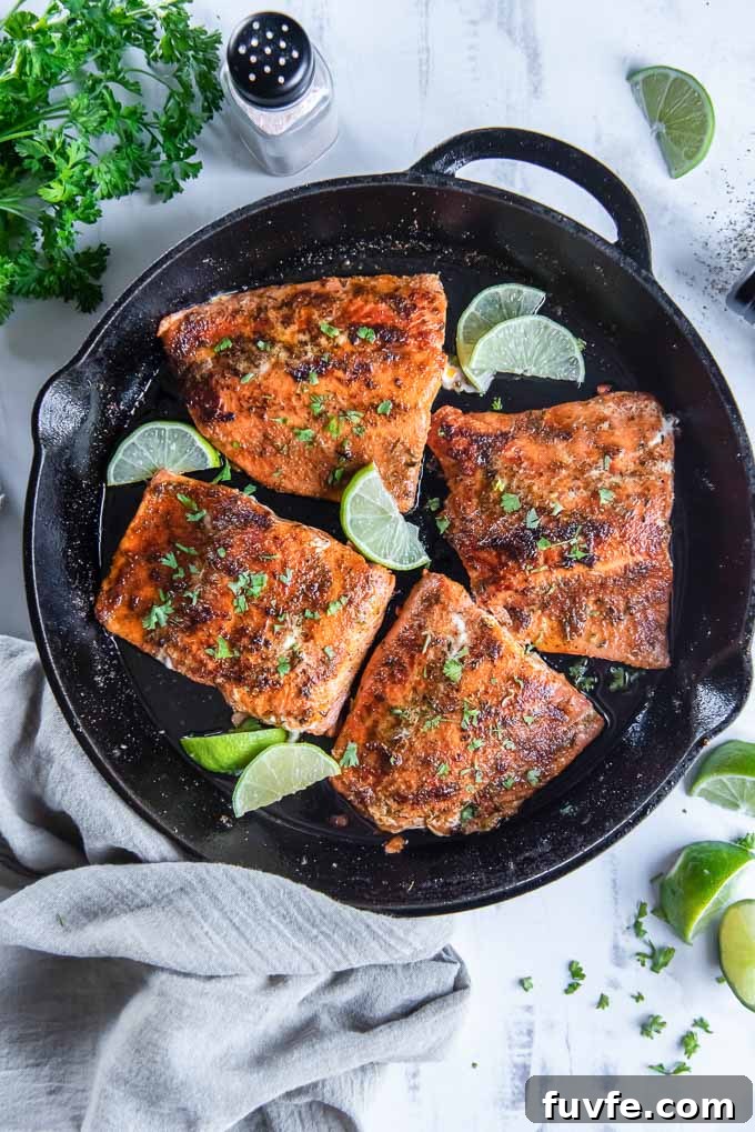Pan-Seared Cajun Blackened Salmon Recipe 3 Blackened salmon filets in a cast iron skillet with limes