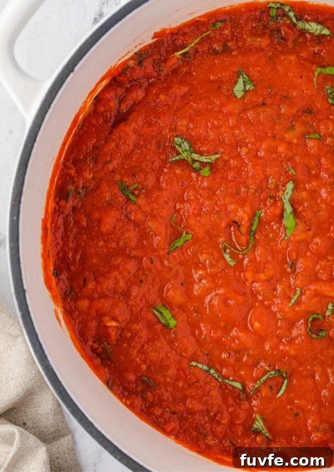 Classic Homemade Marinara Sauce Recipe 2 Homemade marinara sauce in a dutch oven with basil on top