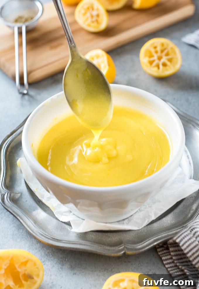 Lemon curd drizzling from a spoon