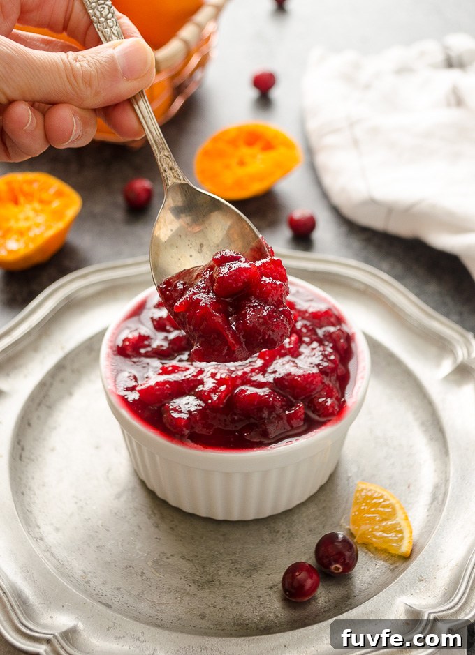 Spoonful of cranberry orange sauce over a ramekin