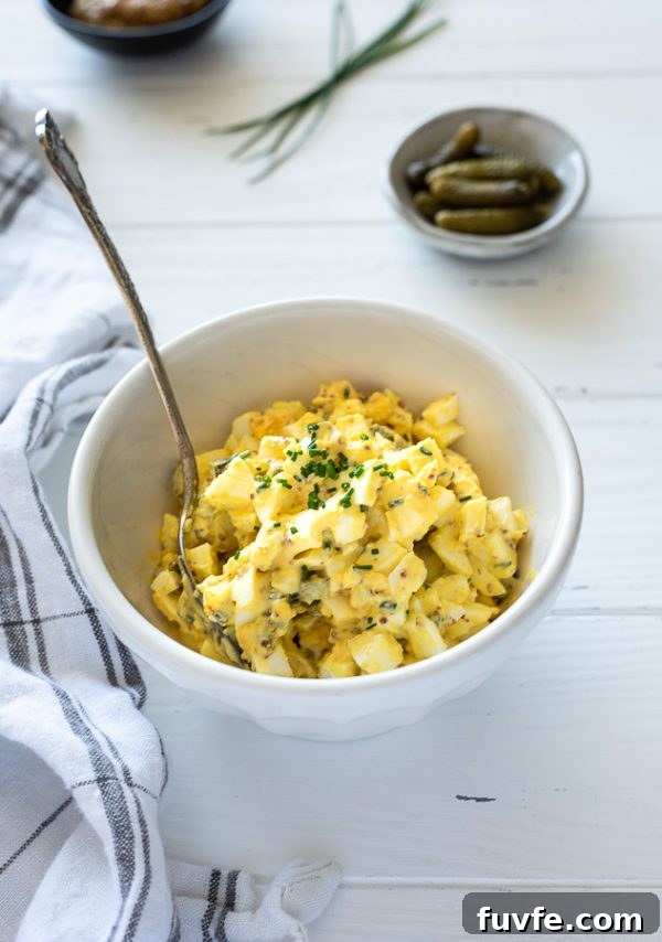 french egg salad in a bowl with chives on top